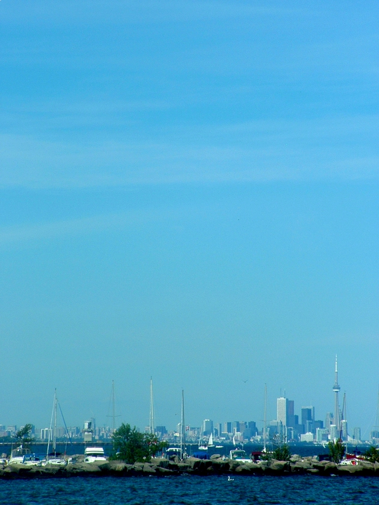 Lots of sky, the Toronto skyline, and a marina.