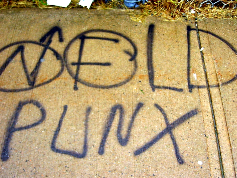 Graffiti on a sidewalk that says NFLD Punx