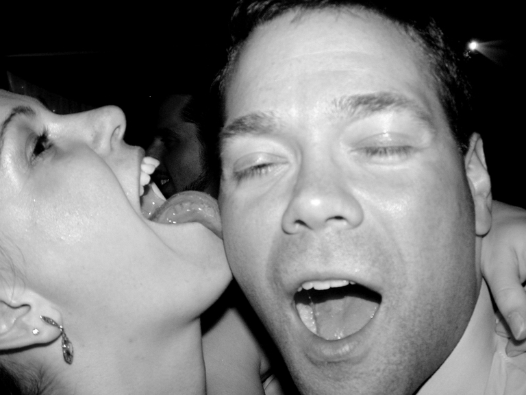 A woman licking a man at a wedding