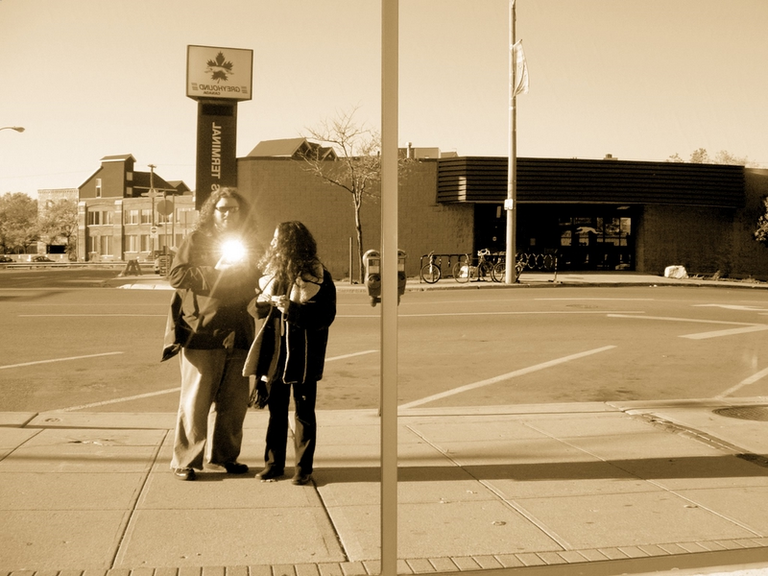 sepia self-portrait with the bus terminal in the background