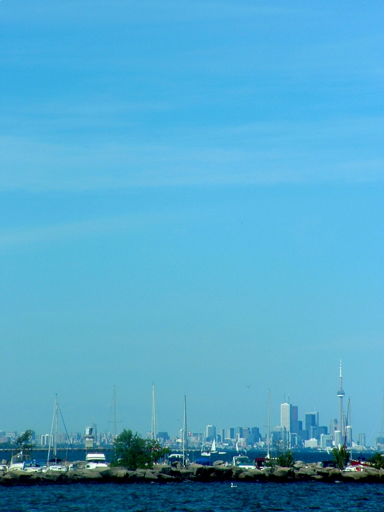 Lots of sky, the Toronto skyline, and a marina.